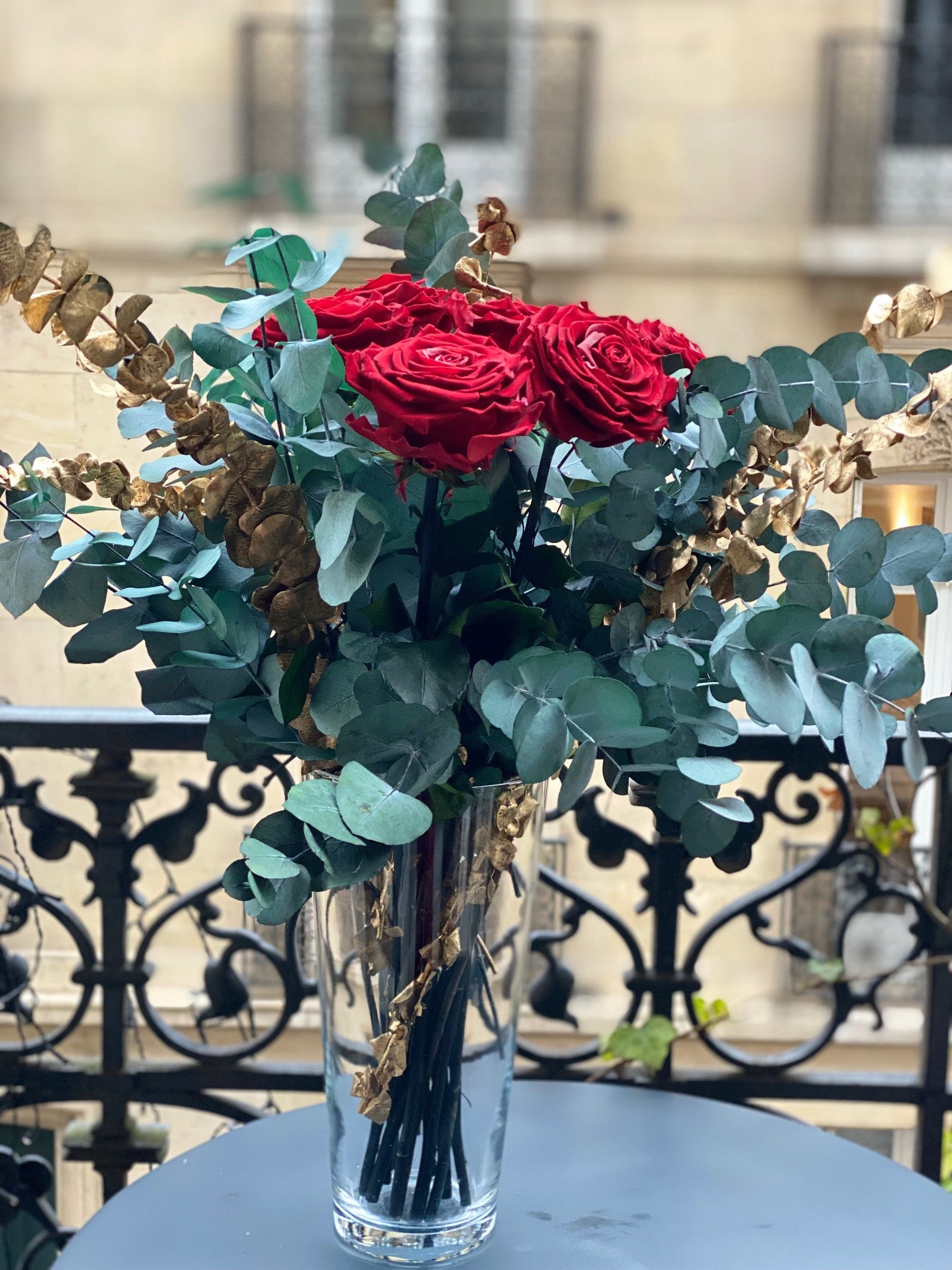 Bouquet éternel Versailles : roses rouges, eucalyptus bleu-gris et touches dorées en vase de cristal – Maison Jalby 1830