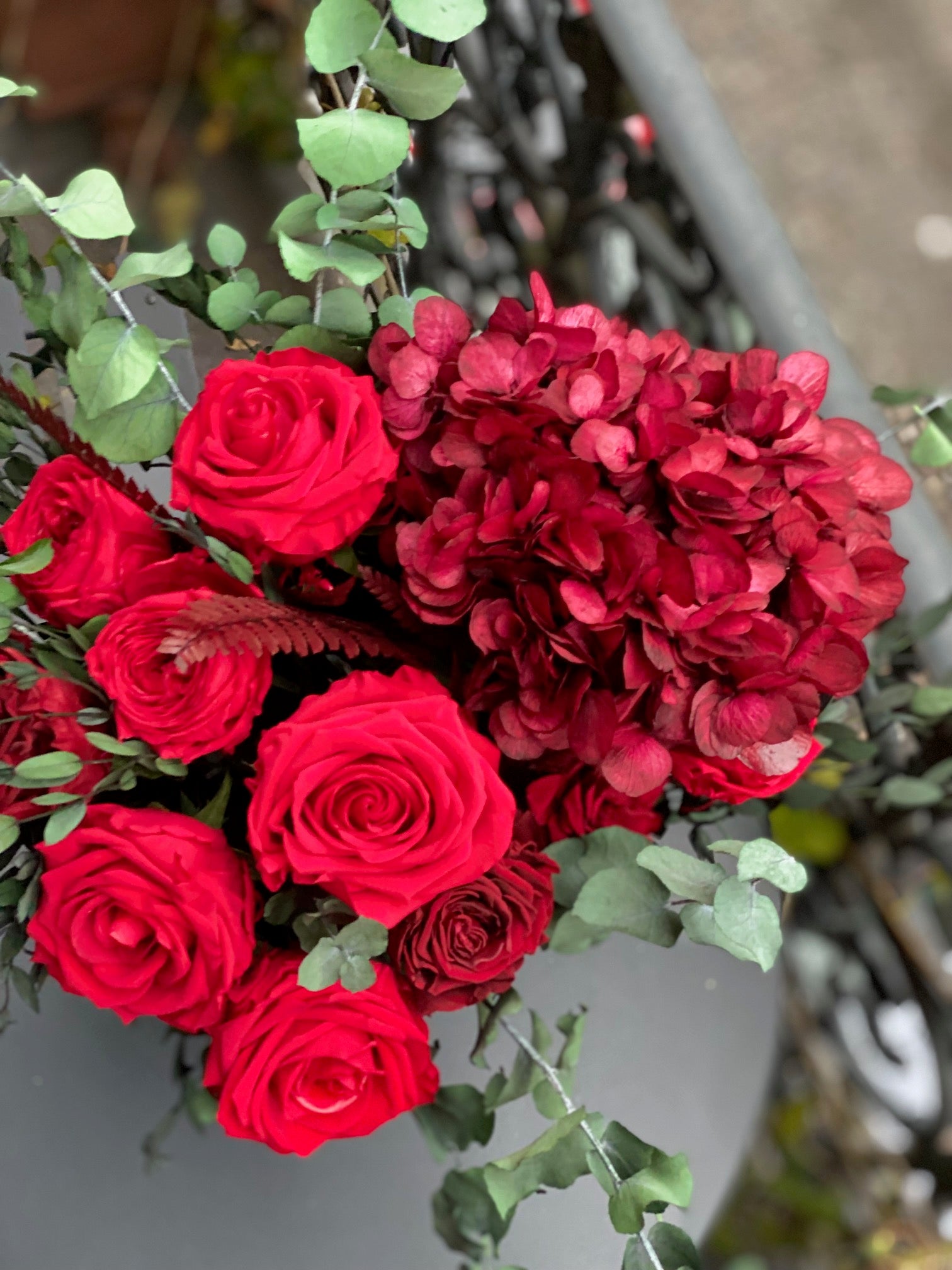 Grande composition éternelle Gustave Moreau : roses rouges et cascade bordeaux en vase de cristal – Maison Jalby 1830
