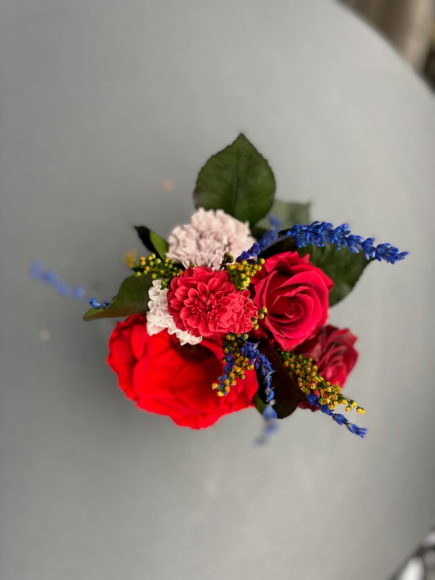 Bouquet éternel Matisse : fleurs stabilisées rouge intense avec touches cobalt et blanc, dans un vase en cristal.