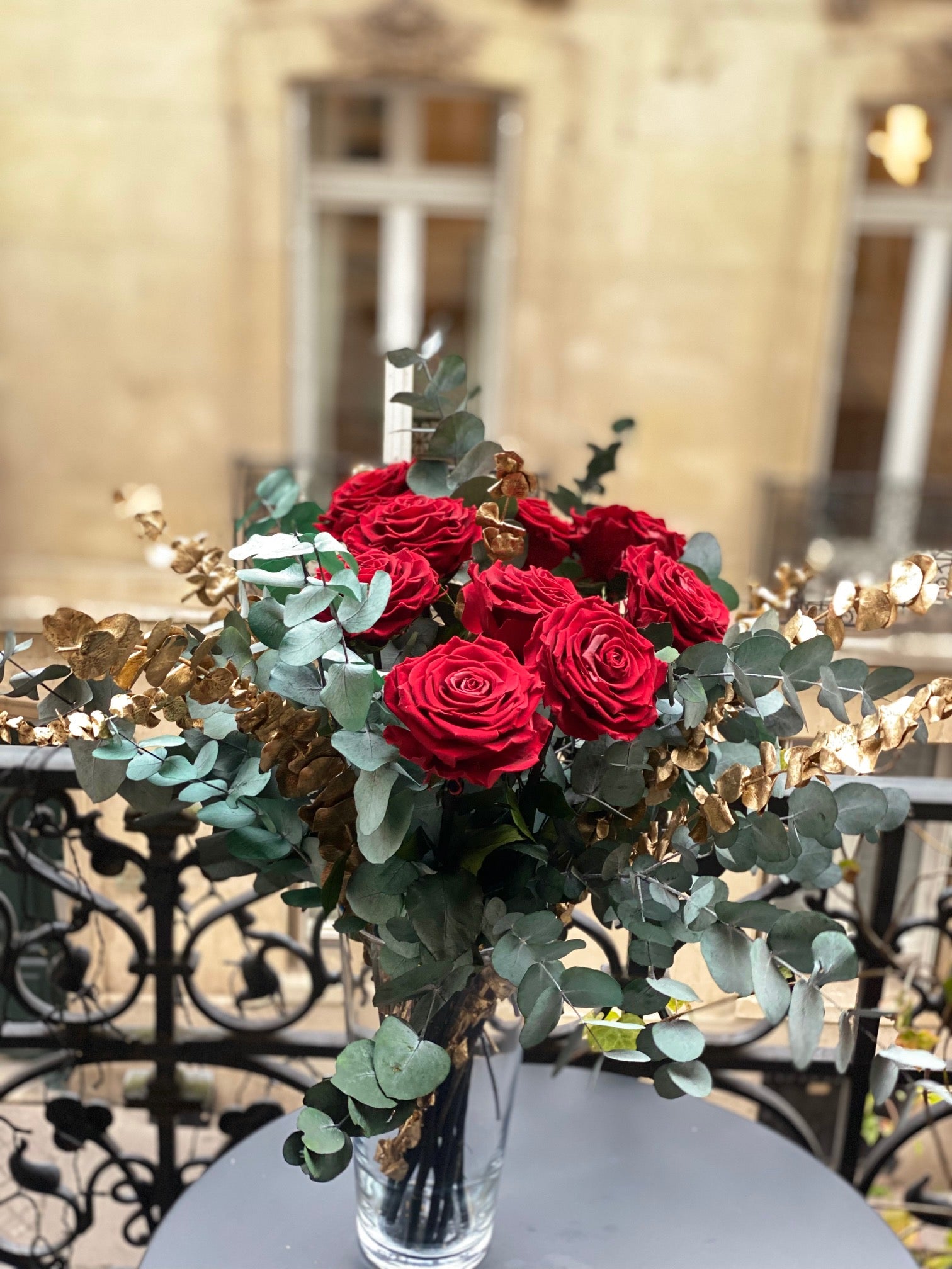 Bouquet éternel Versailles : roses rouges, eucalyptus bleu-gris et touches dorées en vase de cristal – Maison Jalby 1830