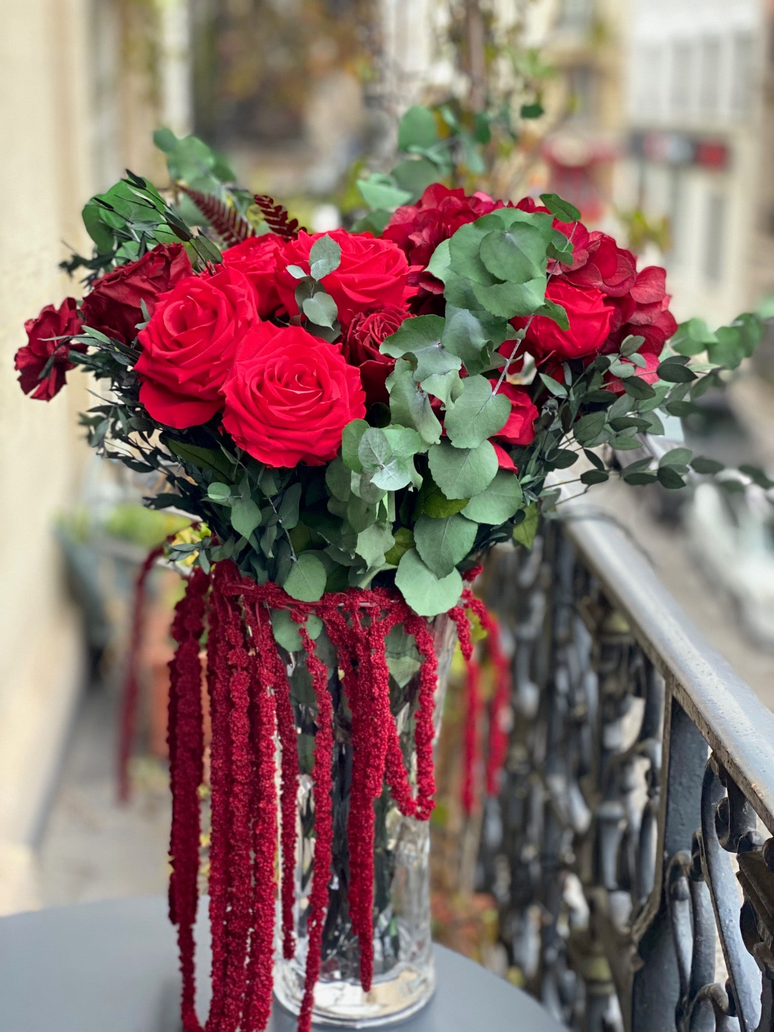 Grande composition éternelle Gustave Moreau : roses rouges et cascade bordeaux en vase de cristal – Maison Jalby 1830