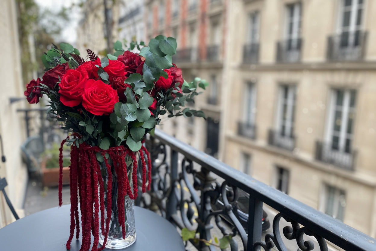 Grande composition éternelle Gustave Moreau : roses rouges et cascade bordeaux en vase de cristal – Maison Jalby 1830