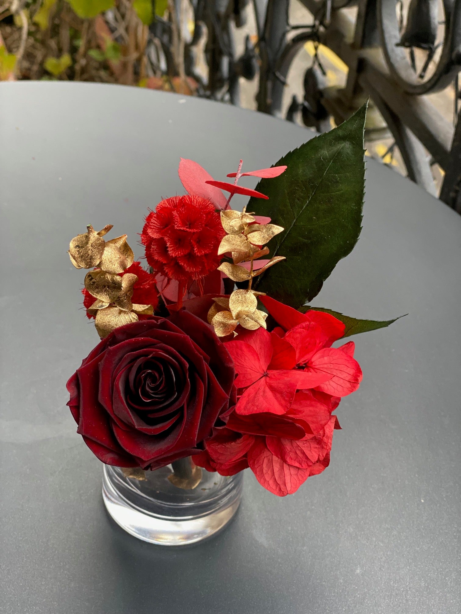 Mini bouquet éternel Perronneau : rose bordeaux et fleurs rouges avec touches dorées en vase de cristal – Maison Jalby 1830