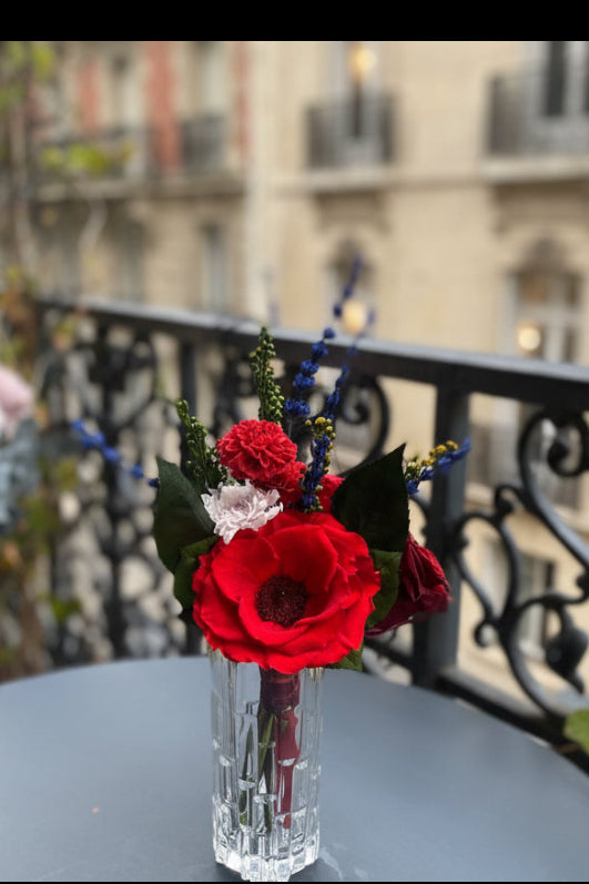 Bouquet éternel Matisse : fleurs stabilisées rouge intense avec touches cobalt et blanc, dans un vase en cristal.